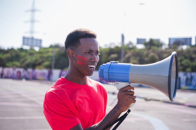 Young black man shouting through the megaphone and claiming his rights