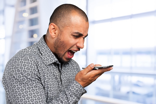 Young and black man yelling at the cellphone