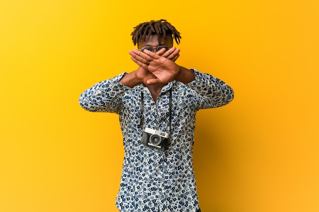 Young black rasta man wearing a vacation look doing a denial gesture