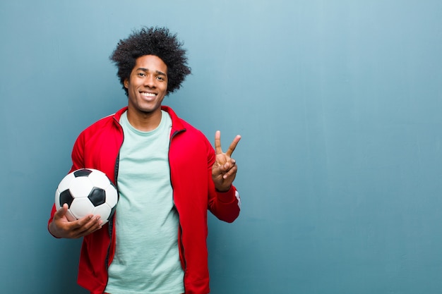 Young black sports man with a soccer ball   blue grunge wa