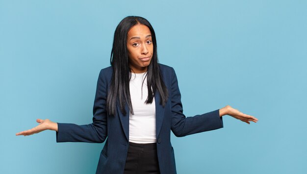 Young black woman feeling puzzled and confused, unsure about the correct answer or decision, trying to make a choice. business concept