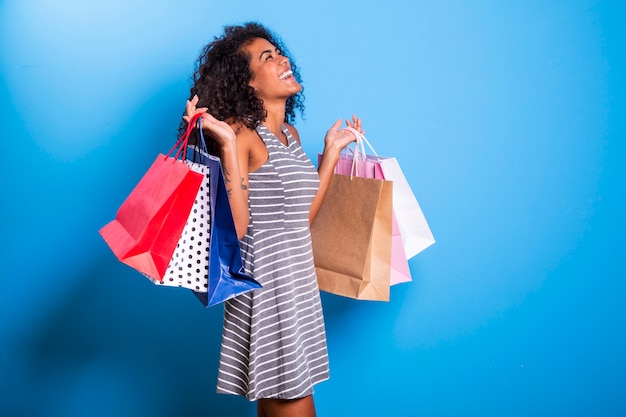 Young black woman holding shopping bags  