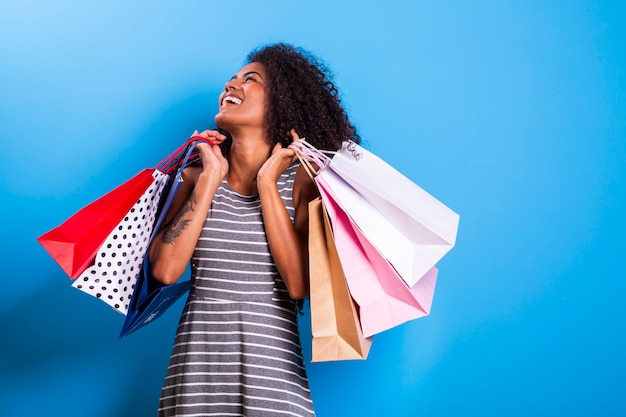 Young black woman holding shopping bags  