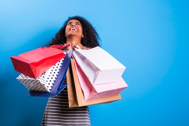 Young black woman holding shopping bags  