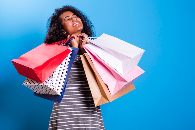 Young black woman holding shopping bags  