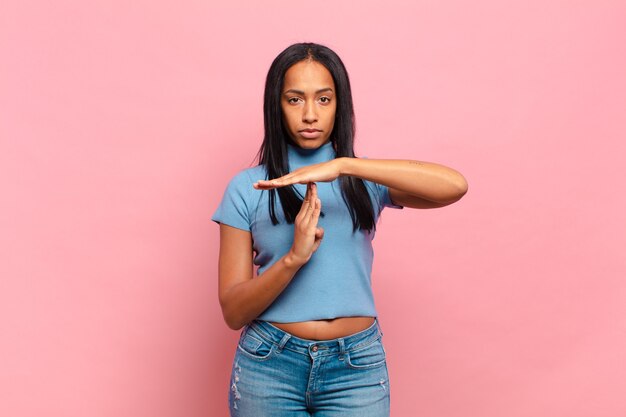 Young black woman looking serious, stern, angry and displeased