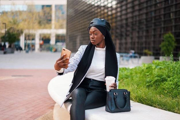 Young black woman taking selfie on smartphone in park