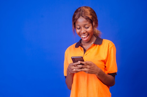 Young black woman using her phone looking amazed