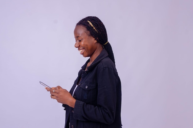 Young black woman using her phone looking surprised