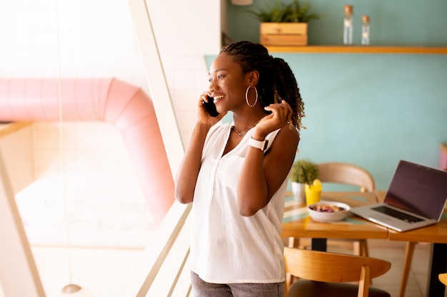 Young black woman using mobile phone in the cafe