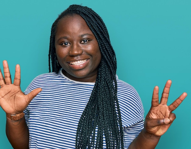 Young black woman with braids wearing casual clothes showing and pointing up with fingers number eight while smiling confident and happy