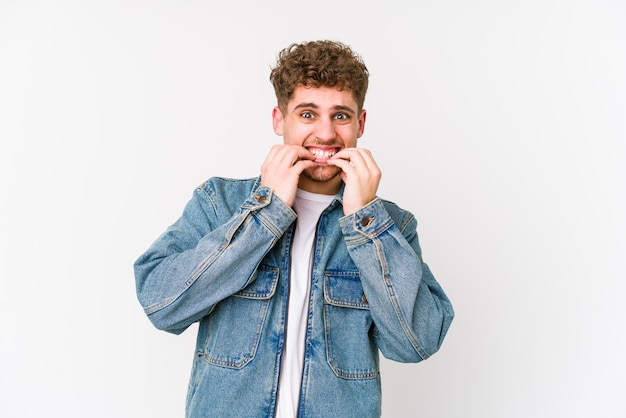 Young blond curly hair caucasian man isolated biting fingernails, nervous and very anxious.