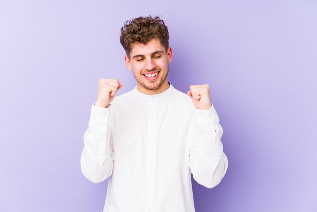 Photo young blond curly hair caucasian man isolated celebrating a victory, passion and enthusiasm, happy expression.