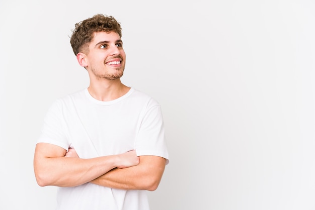 Young blond curly hair caucasian man isolated smiling confident with crossed arms.