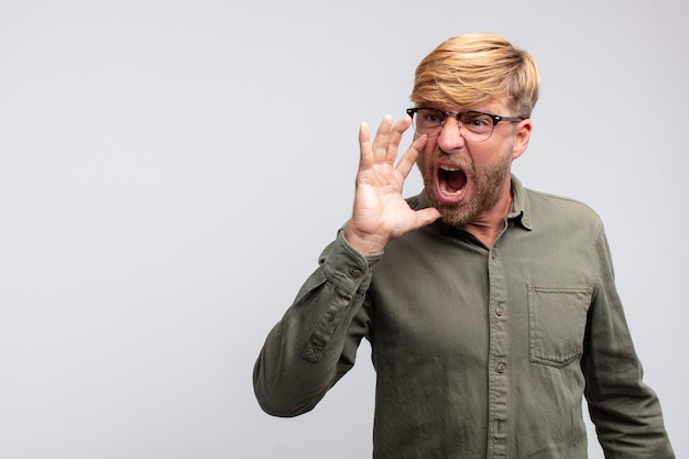 Young blond man shouting angry