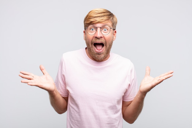 Young blond man surprised or shocked