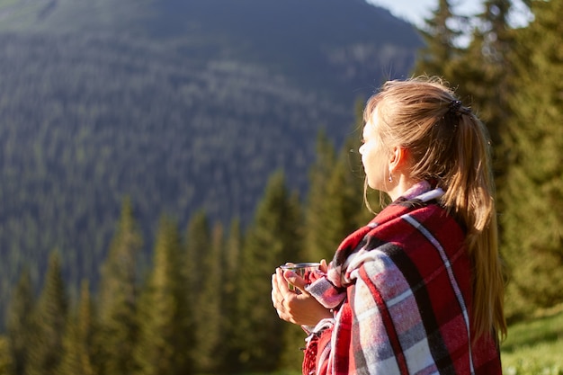 Young blond woman relaxing in mountains