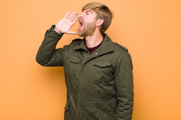 Photo young blonde bearded man yelling loudly and angrily