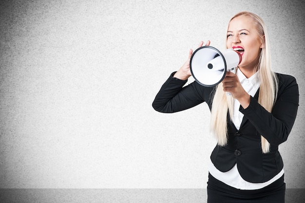 Young Blonde Business Woman screaming through megaphone