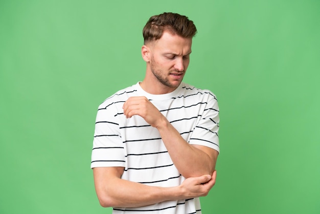 Photo young blonde caucasian man over isolated background with pain in elbow