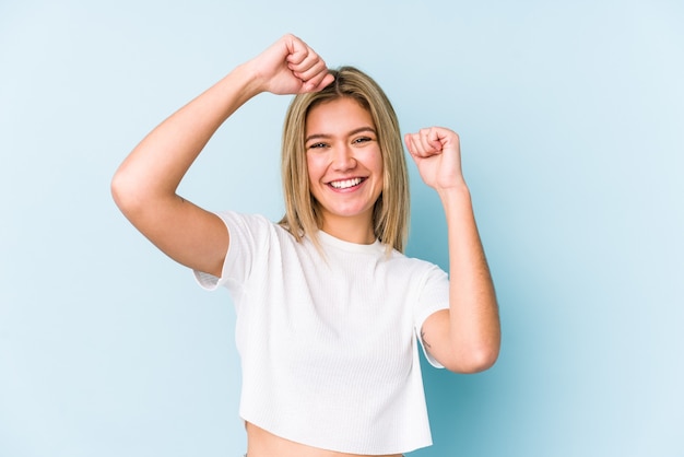 Young blonde caucasian woman isolated celebrating a special day, jumps and raise arms with energy.