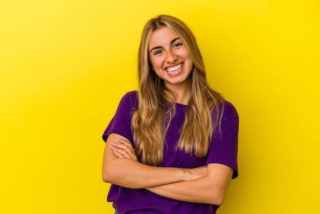 Young blonde caucasian woman isolated on yellow background happy, smiling and cheerful.