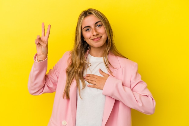 Young blonde caucasian woman   taking an oath, putting hand on chest.