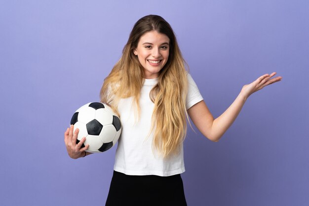 Young blonde football player woman isolated pointing to the side to present a product