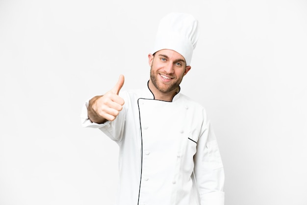 Young blonde man Chef over isolated white background with thumbs up because something good has happened