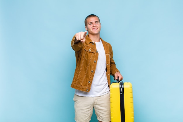 Young blonde man pointing at camera with a satisfied, confident, friendly smile, choosing you