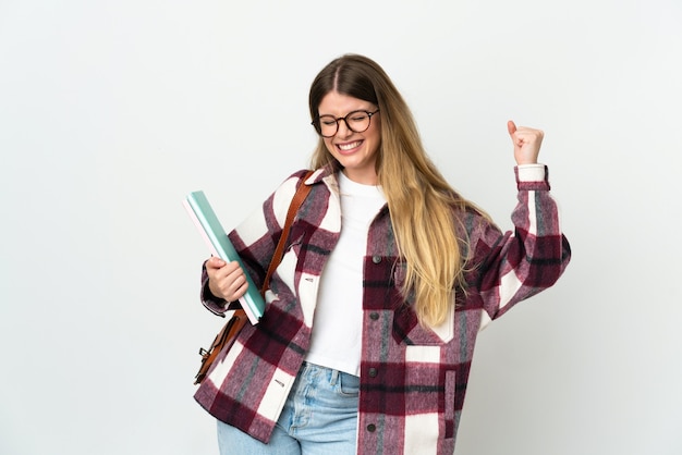 Young blonde student woman posing isolated against the blank wall