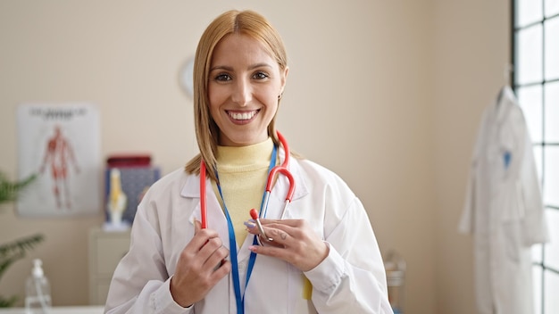 Young blonde woman doctor smiling confident standing at clinic