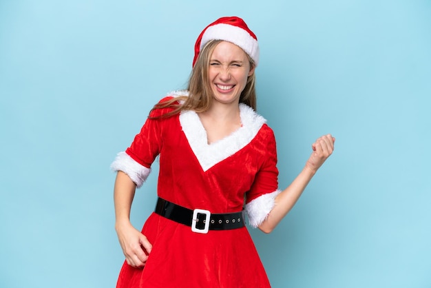 Young blonde woman dressed as mama claus isolated on blue background making guitar gesture