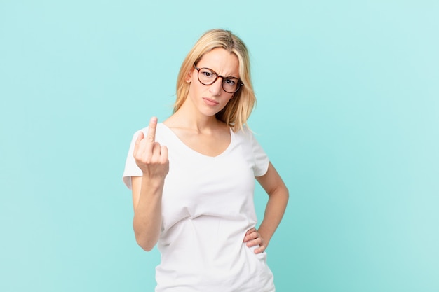 Young blonde woman feeling angry, annoyed, rebellious and aggressive