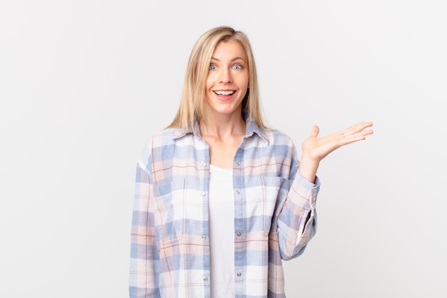 Young blonde woman feeling happy, surprised realizing a solution or idea