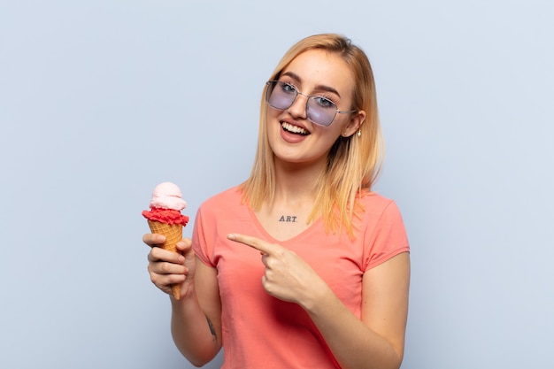 Young blonde woman feeling joyful and surprised