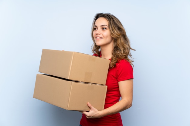 Young blonde woman holding a box to move it to another site