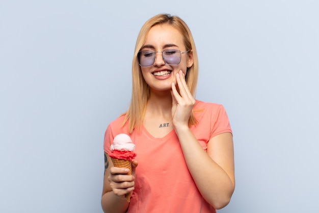 Young blonde woman holding cheek and suffering painful toothache, feeling ill, miserable and unhappy, looking for a dentist