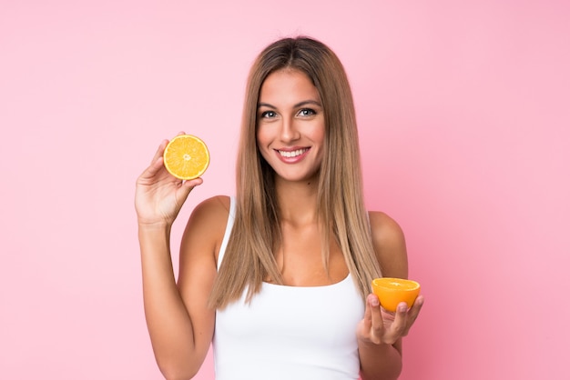 Young blonde woman holding an orange