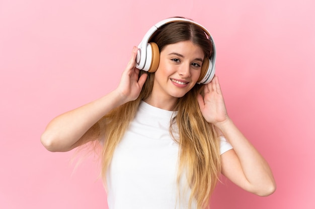 Young blonde woman over isolated space listening music