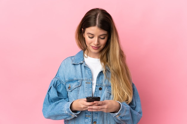 Young blonde woman isolated using mobile phone