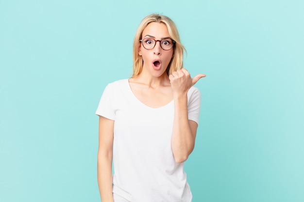 Young blonde woman looking astonished in disbelief