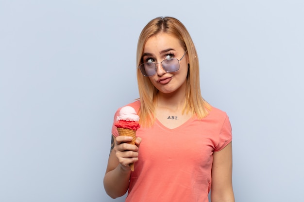 Young blonde woman looking goofy and funny with a silly cross-eyed expression, joking and fooling around