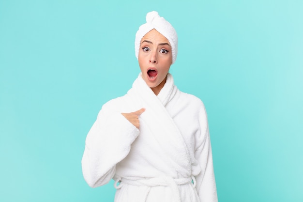 Young blonde woman looking shocked and surprised with mouth wide open, pointing to self. shower concept.