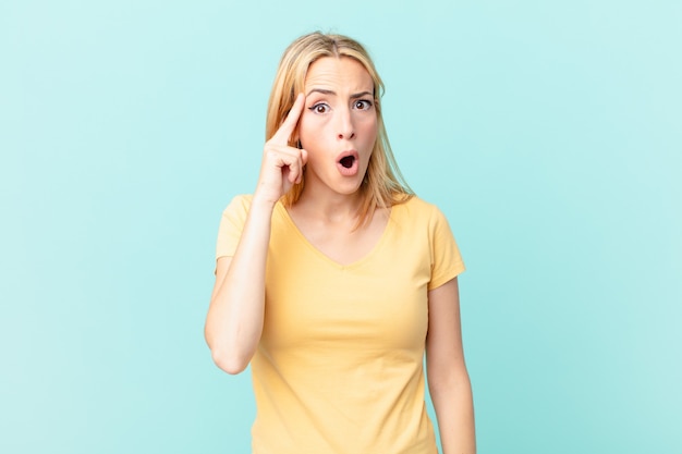 Young blonde woman looking surprised, realizing a new thought, idea or concept