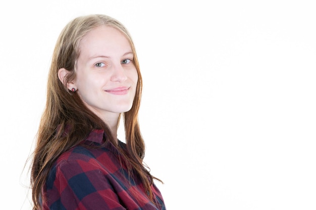 Young blonde woman portrait smiling and pensive in front of white copy space posing in close up portrait in studio shot