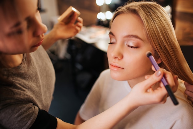 Young blonde woman sit on chair in beauty room