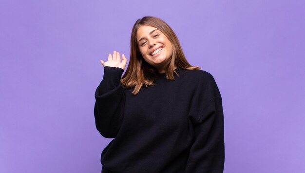 Young blonde woman smiling happily and cheerfully