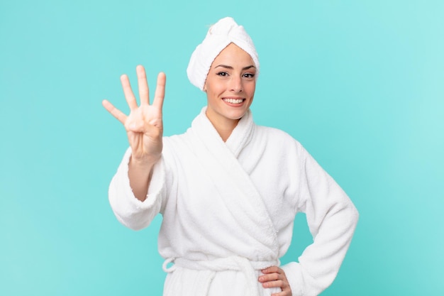 Young blonde woman smiling and looking friendly, showing number four. shower concept.