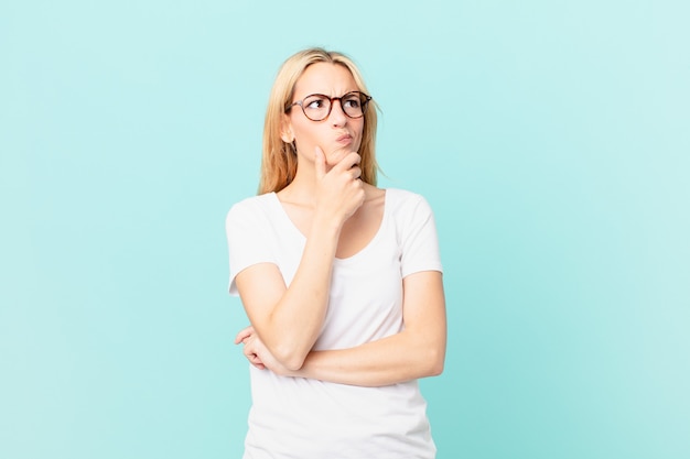 Young blonde woman thinking, feeling doubtful and confused